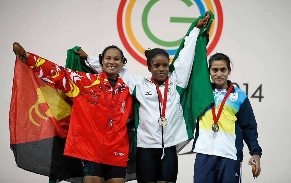Chika Amalaha of Nigeria, centre , gold medal, Dika Toua of Papua New Guinea, left silver medal and Santoshi Matsa of India bronze medal pose for photographs with their medals for the women`s weightlifting 53 kg after the medal ceremony at the Commonwealth Games Glasgow 2014, in Glasgow, Scotland.