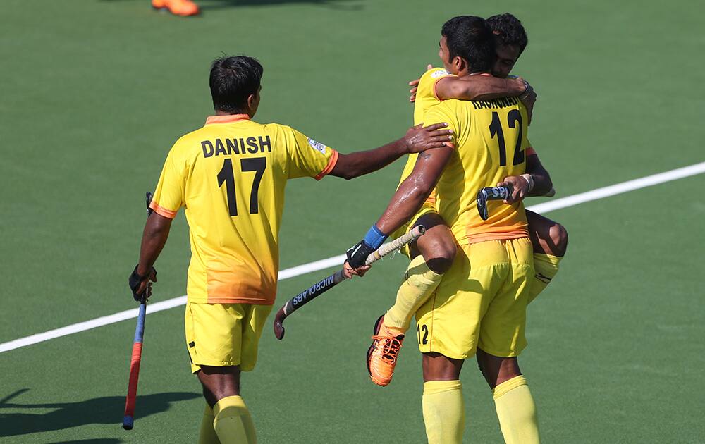 India`s Raghunath Vokaliga reacts with Chandanda Nikkin as Danish Mujtaba looks on following a goal by Vokkaliga during his sides field hockey match against Wales at the Commonwealth Games Glasgow 2014, Glasgow National Hockey Centre, Scotland.