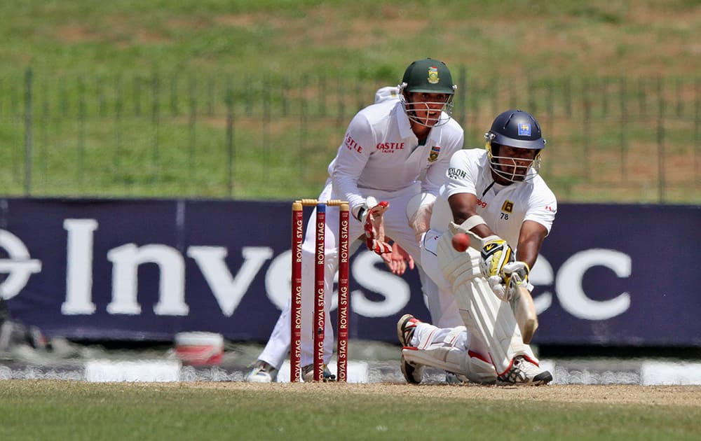 Sri Lanka`s Rangana Herath plays a shot in front of South Africa`s Quinton de Kock on the second day of their second cricket test match in Colombo, Sri Lanka.