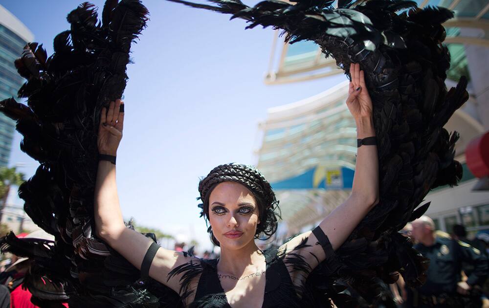 A woman dressed as the character Katniss Everdeen from the movie, `The Hunger Games: Catching Fire,` poses in front of Comic-Con in San Diego.