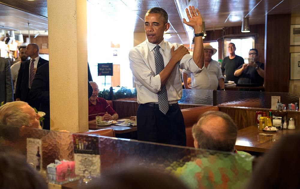 President Barack Obama shows his free throw technique to a couple of people at Canter`s Restaurant Bakery Delicatessen along Fairfax Avenue in Los Angeles.