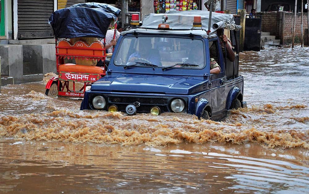 A police vehicle moves through waterlogged road in Guwahati on Thursday following a heavy downpour.