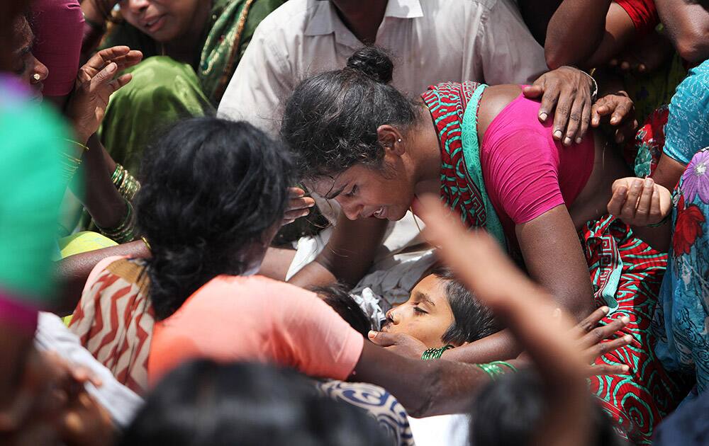 An unidentified woman cries by the body of a victim of an accident in Medak district in the southern Indian state of Telangana.