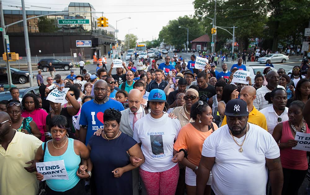 Ellisha Flagg, sister of Eric Garner, center, leads demonstrators on a march towards the 120th Precinct following a vigil demanding justice for her brother who died while being arrested by New York City police in New York.