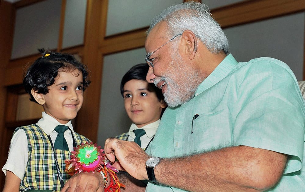 Children tying ‘Rakhi’ to Prime Minister Narendra Modi on the occasion of Raksha Bandhan in New Delhi.