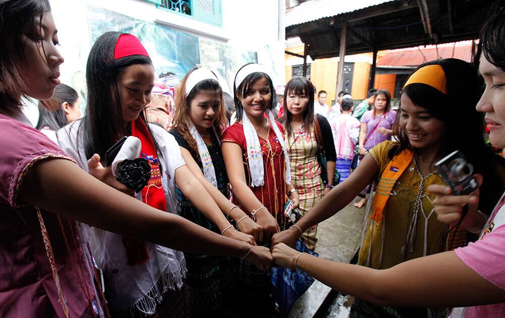 Clad in traditional attire, Karen girls show their white threads around their wrists during a traditional `Wrist Tying` festival at a pagoda in Yangon, Myanmar.