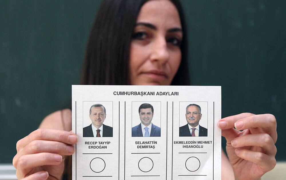 A polling station official holds a ballot paper with pictures of candidates, from left, Recep Tayyip Erdogan, Selahattin Demirtas and Ekmeleddin Mehmet Ihsanoglu for the Turkey`s presidential election at a polling station in Ankara, Turkey.