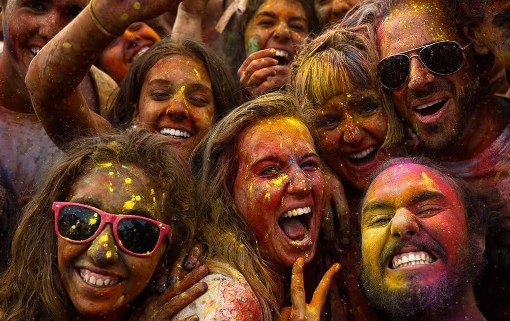 Revelers of the Holi Festival of Colours pose for a selfie, covered in coloured powder, in Madrid, Spain.