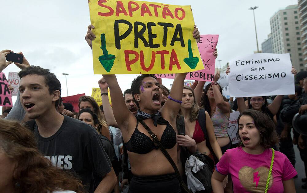 A woman shouts slogans as she holds a sign that reads in Portuguese; `Lesbian, Black, and Prostitute,` during the `Slutwalk,`an annual protest march against sexual harassment, on Copacabana Beach, in Rio de Janeiro, Brazil.