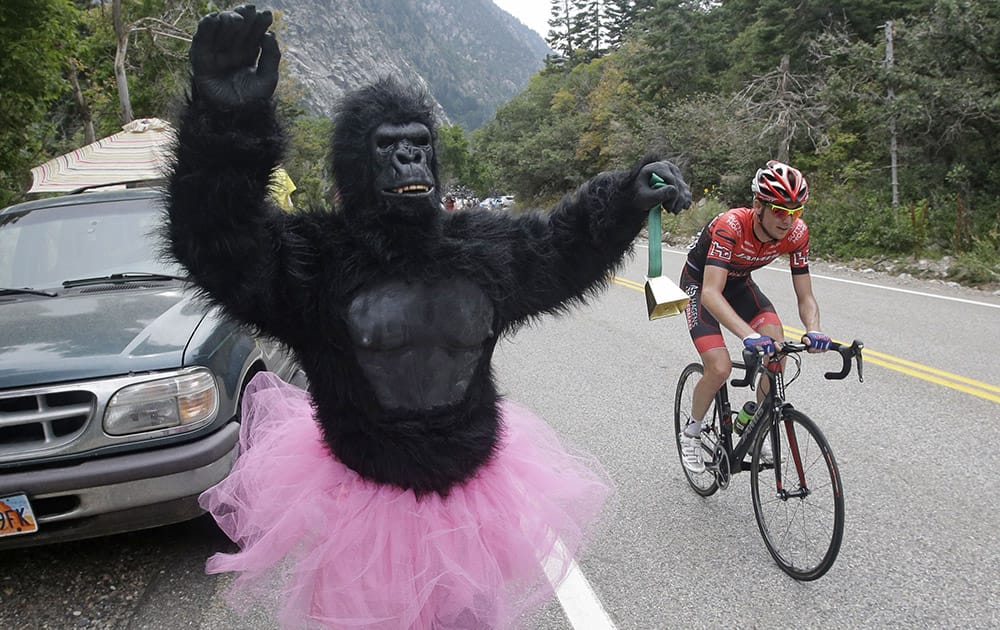 A supporter dressed in a costume stands on the edge of the highway during the sixth stage of the Tour of Utah cycling race.