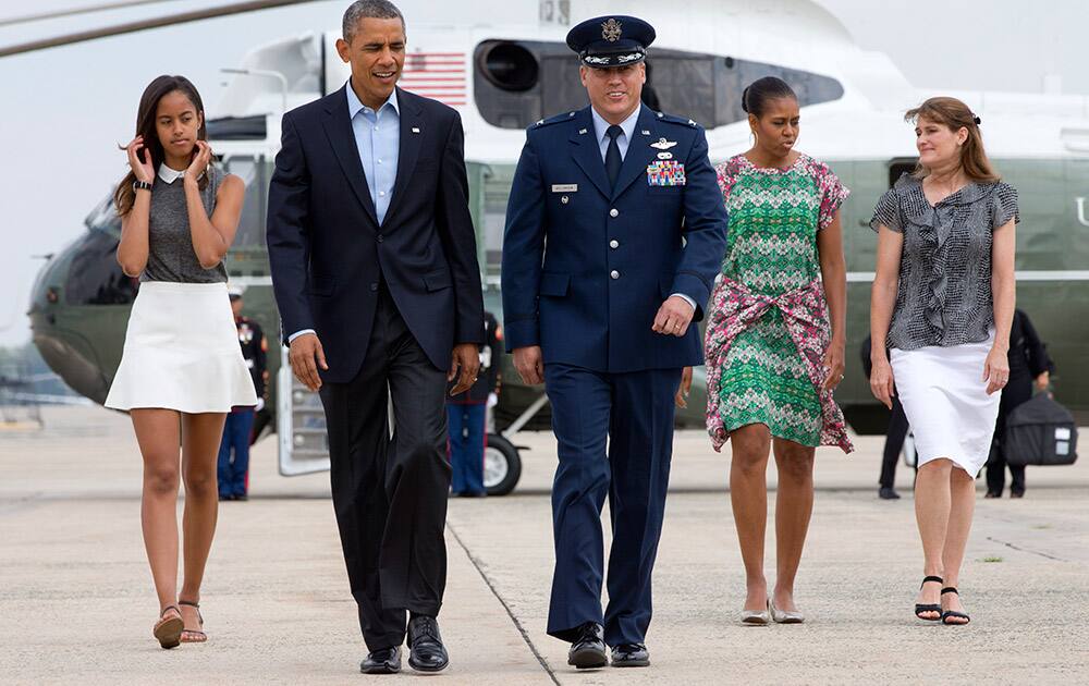 President Barack Obama second from left, walks from Marine One with Vice Commander of the 89th Airlift Wing at Andrew Air Force Base Col.
