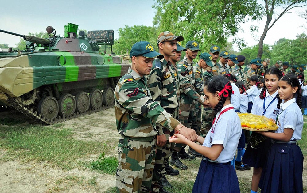 School girls tie rakhi on the wrists of Army soldiers on the eve of Raksha Bandhan festival in Patiala.