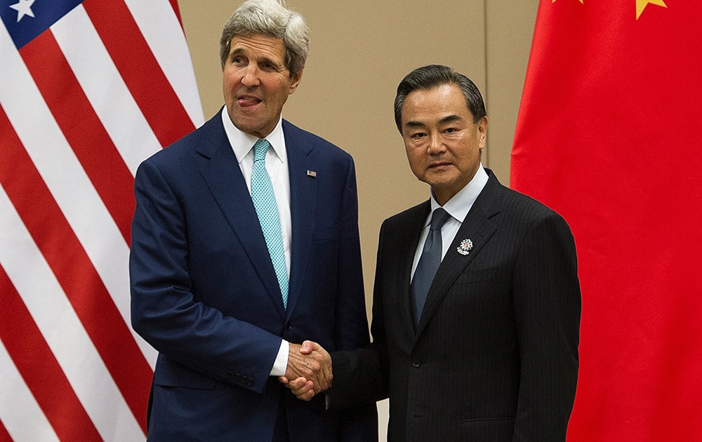 US Secretary of State John Kerry, left, shakes hands with Chinese Foreign Minister Wang Yi as they pose for photos before their meeting at the 47th ASEAN Foreign Ministers` Meeting in Naypyitaw, Myanmar.