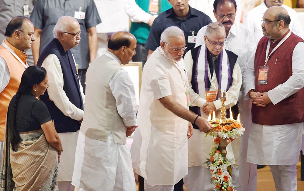 Prime Minister Narendra Modi lighting the lamp as BJP President Amit Shah and senior leaders LK Advani, M M Joshi, Rajnath Singh, M Venkaiah Naidu, Arun Jaitley and Gujarat CM Anandiben Patel look on during the party`s National Council meet in New Delhi.