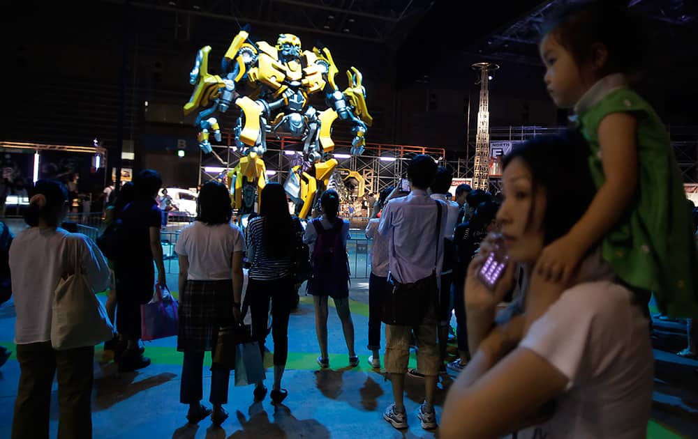 Visitors look at a model of Transformers character displayed at Transformers Expo in Yokohama. Latest film, Transformers: Age of Extinction, now is shown in Japan.