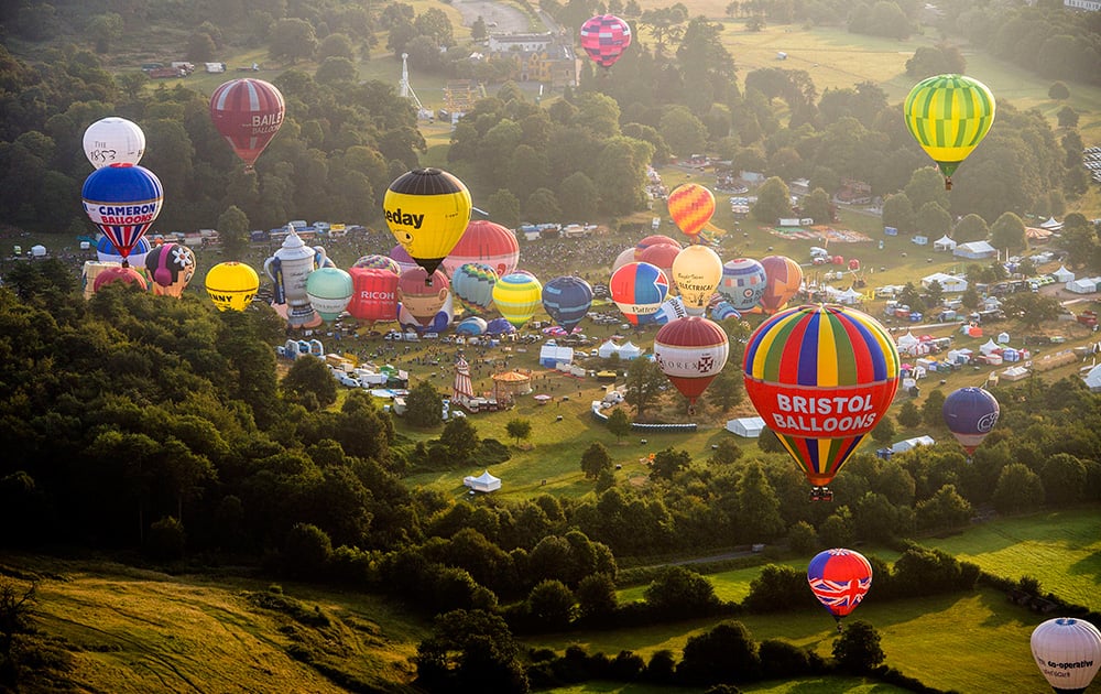 Hot air balloons lift off during a mass ascent at the 36th International Balloon Fiesta at the Ashton Court Estate near Bristol, England.
