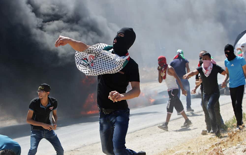 Palestinian protesters hurl stones towards Israeli soldiers during a demonstration against the Israeli military action in Gaza, at the Beit Fourik checkpoint near the West Bank of Nablus.