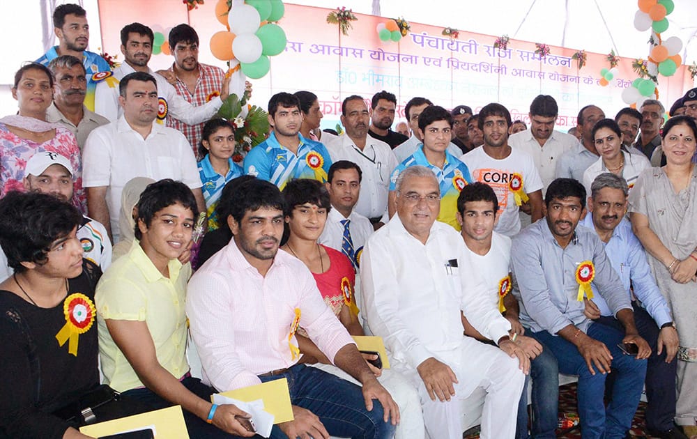 Haryana Chief Minister Bhupinder Singh Hooda, state Education Minister Geeta Bhukkar (extreme R) and Sports Minister Sukhbir Kataria (second R) with CWG medalists in Sonipat.