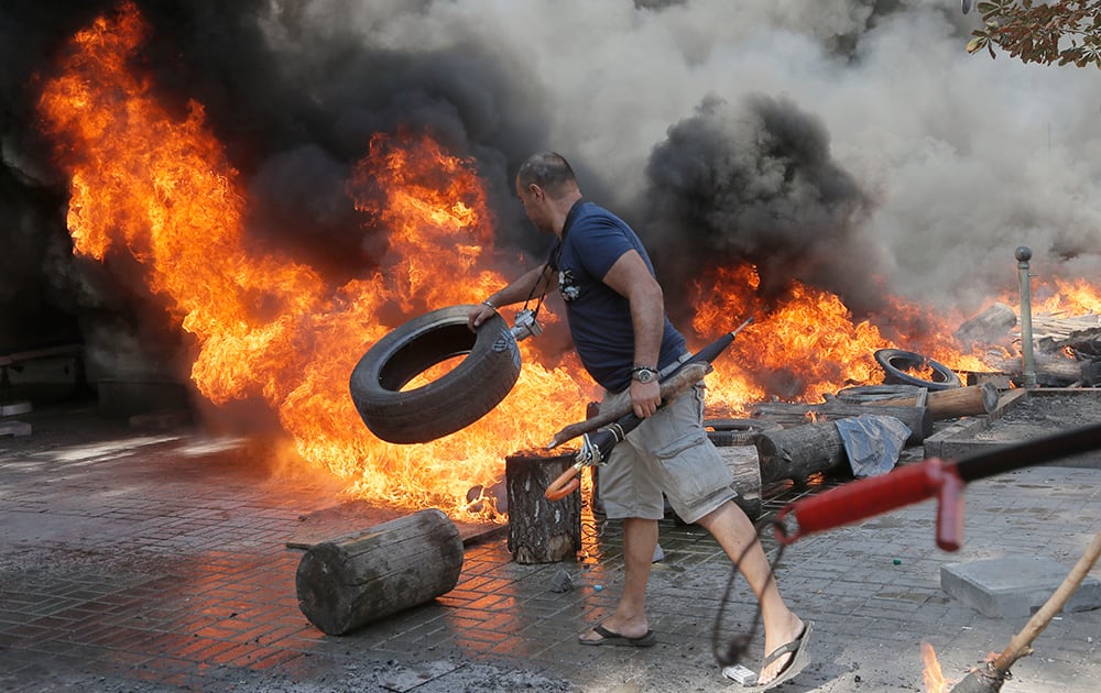 An activist burns tyres during a clash with a special forces police battalion, in Independence Square, Kiev, Ukraine.