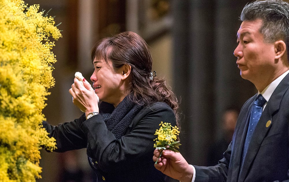 Sprigs of wattle blossoms are placed on a wreath by mourners during a national memorial service for the victims of Malaysia Airlines Flight 17 at St Patrick’s Cathedral in Melbourne, Australia.