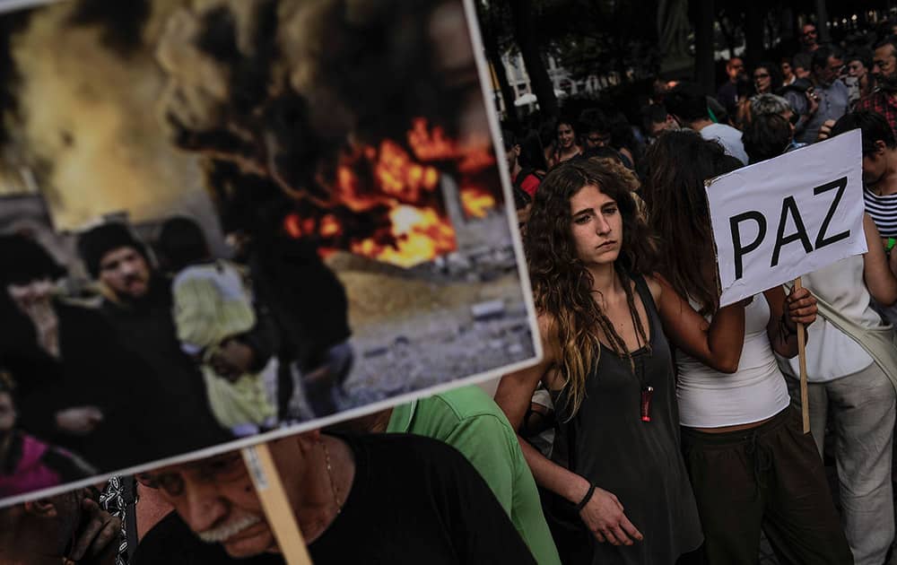 A woman holds a banner reading, `Peace`, during a protest against Israel`s offensive in Gaza, in Pamplona, Northern Spain.