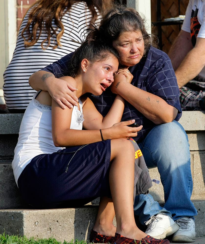 Lisa Kepler, daughter of officer Shannon Kepler, hugs Pam Wilkins on the steps of her home in Tulsa, Okla., Wednesday, Aug. 6, 2014, the morning after Jeremy Lake was shot by officer Kepler the night before. Lisa and Jeremy had been dating for a week, and both had been living at Wilkins` home.