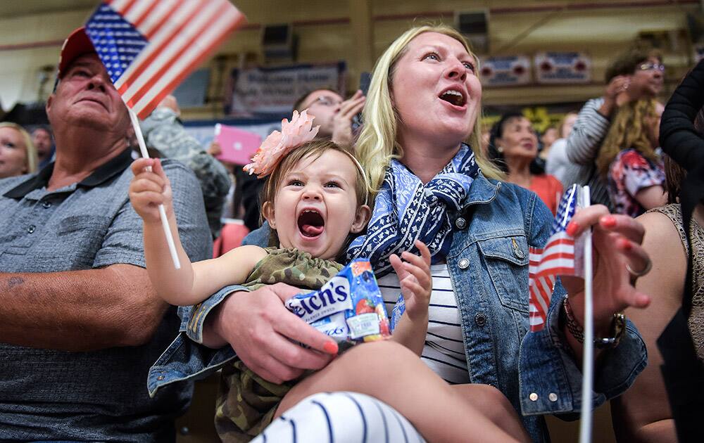 Emelya Barowitz, 1, screams and waves a flag as she waits with a relative for her father, Sgt. John Barowitz, to return from Afghanistan with about 150 soldiers of the 4th Brigade Combat Team at the Fort Carson Special Events Center in Colorado Springs, Colo.
