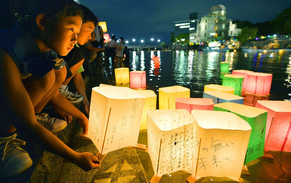 A girl prepares to release paper lanterns with a message for peace on it in the Motoyasu River near the Atomic Bomb Dome in Hiroshima, western Japan. Japan marked the 69th anniversary Wednesday of the atomic bombing of Hiroshima.