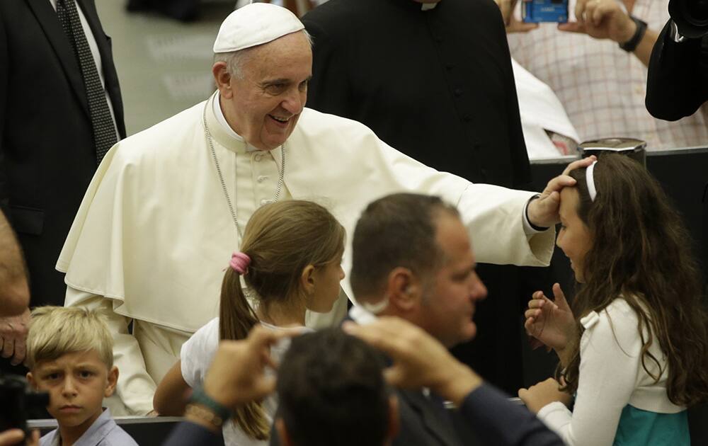 Pope Francis blesses a child during the weekly general audience in the Paul VI hall, at the Vatican.