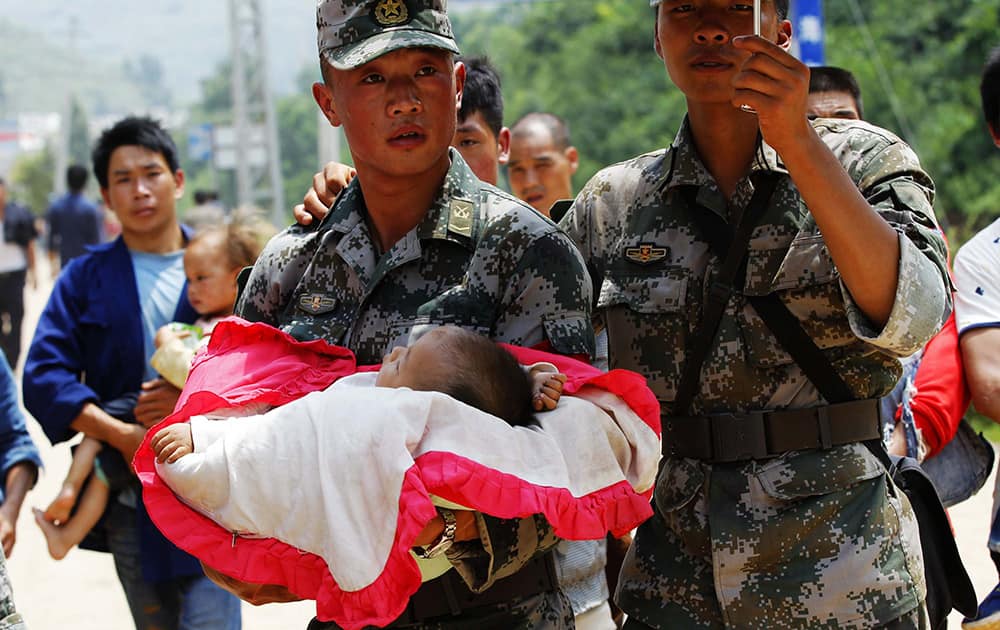 Rescuers transfer a baby in the quake-hit Longquan village of Ludian county, southwest China`s Yunnan Province.