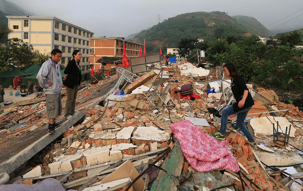 Teachers search for their belongings from the collapsed dormitories at Longquan Middle School in Longtoushan town of Ludian county, southwest China`s Yunnan Province.