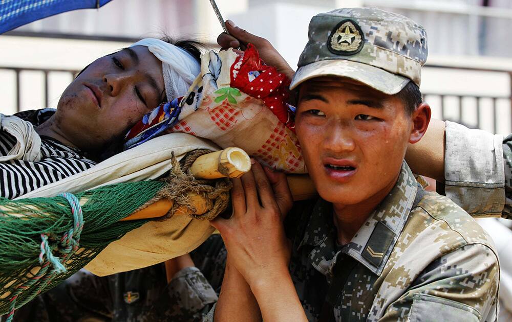 Rescuers transfer an injured woman in the quake-hit Longquan village of Ludian county, southwest China`s Yunnan Province.