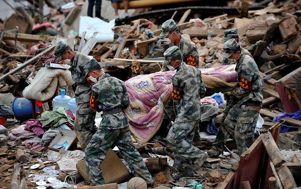 Rescuers transfer the body of a victim in the quake-hit Longtoushan township of Ludian county, southwest China`s Yunnan Province.