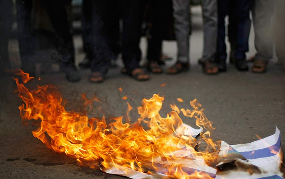 Yemenis burn a representation of an Israeli flag during a protest supporting Gaza in front of Egyptian embassy in Sanaa, Yemen.