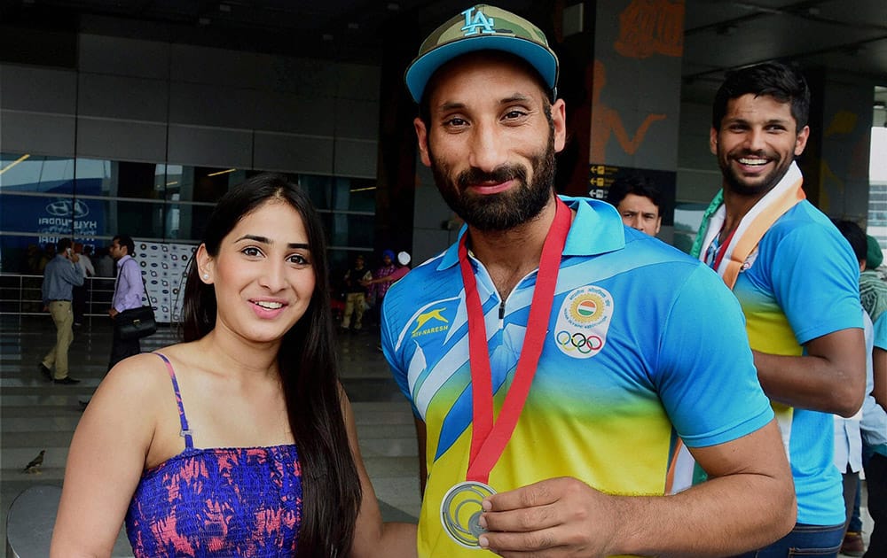 Indian Hockey captain Sardara Singh with his fiancee English Hockey player Ashpal Bhogal on their arrival at the IGI Airport in New Delhi on Tuesday after participating in CWG 2014 at Glasgow.