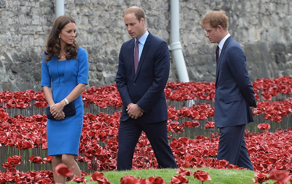 Britain`s Prince William, the Duke of Cambridge, centre, walks with Kate, the Duchess of Cambridge, left and Prince Harry, right, as they view the Tower of London`s `Blood Swept Lands and Seas of Red` poppy installation, to commemorate the 100th anniversary of the outbreak of WWI, in London.