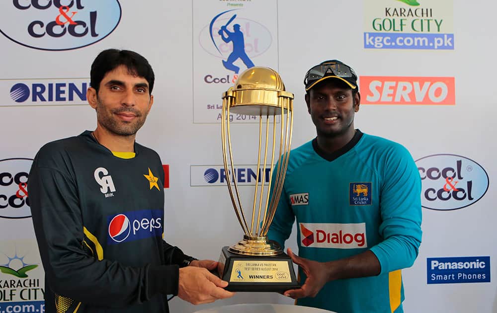 Sri Lankan cricket captain Angelo Mathews, right, and his Pakistani counterpart Misbah-ul-Haq pose for photographers with the series trophy ahead of their first test cricket match against Pakistan in Galle, Sri Lanka.
