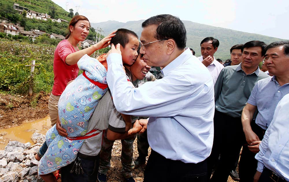Chinese Premier Li Keqiang comforts a child at the earthquake zone in the town of Longtoushan in Ludian County in southwest China`s Yunnan Province.