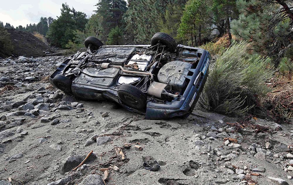 A car lies where it was swept down a wash in the mountain community of Forest Falls in the San Bernardino Mountains.