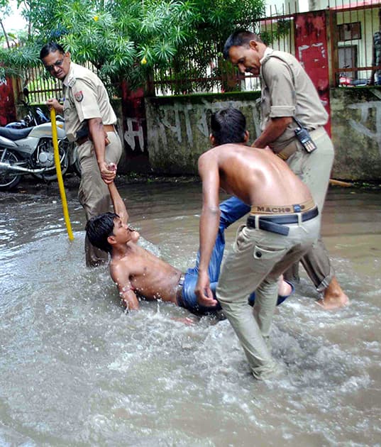 Police arrest students in a waterlogged area during a Chakka Jaam protest by them in Allahabad.