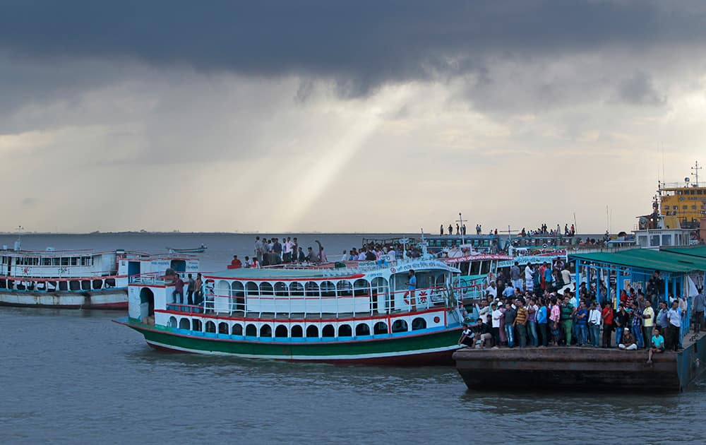 Bangladeshi people gather on the banks of the River Padma after a passenger ferry capsized in Munshiganj district, Bangladesh.