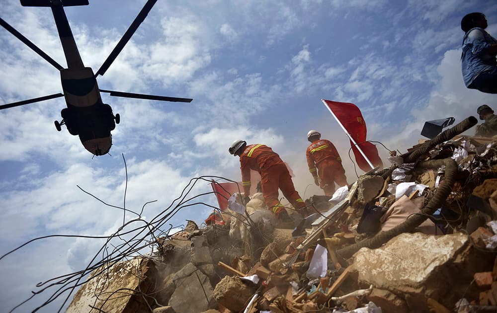 A helicopter flies over rescue workers at the epicenter of an earthquake that struck the town of Longtoushan in Ludian county in southwest China`s Yunnan province .