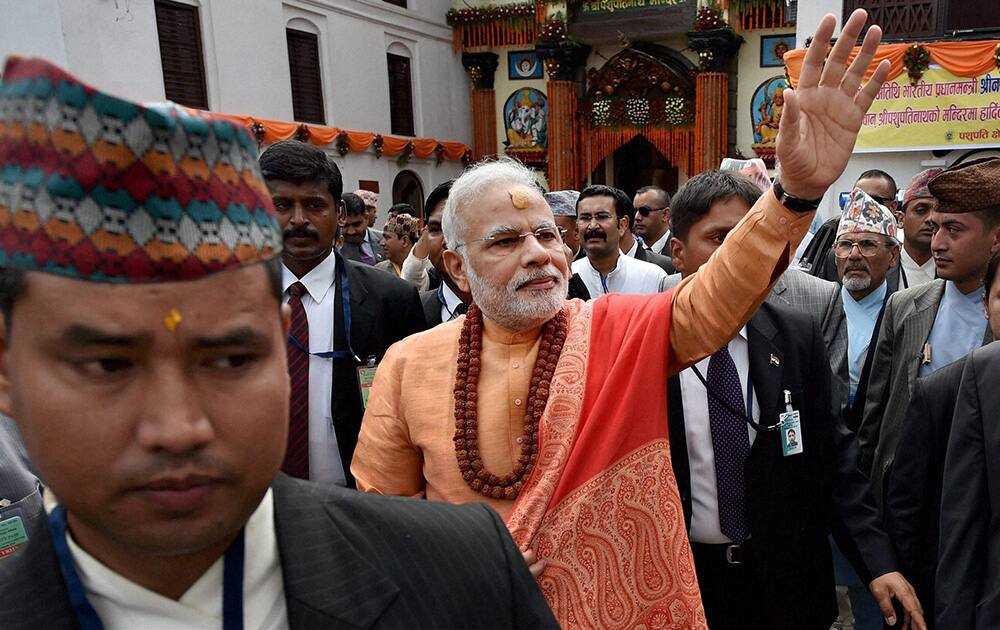 Prime Minister Narendra Modi waves to people as he comes out after praying at the Pashupatinath temple in Kathmandhu Nepal.