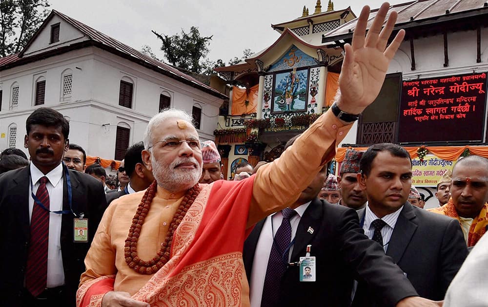 Prime Minister Narendra Modi waves to people as he comes out after praying at the Pashupatinath temple in Kathmandhu Nepal.