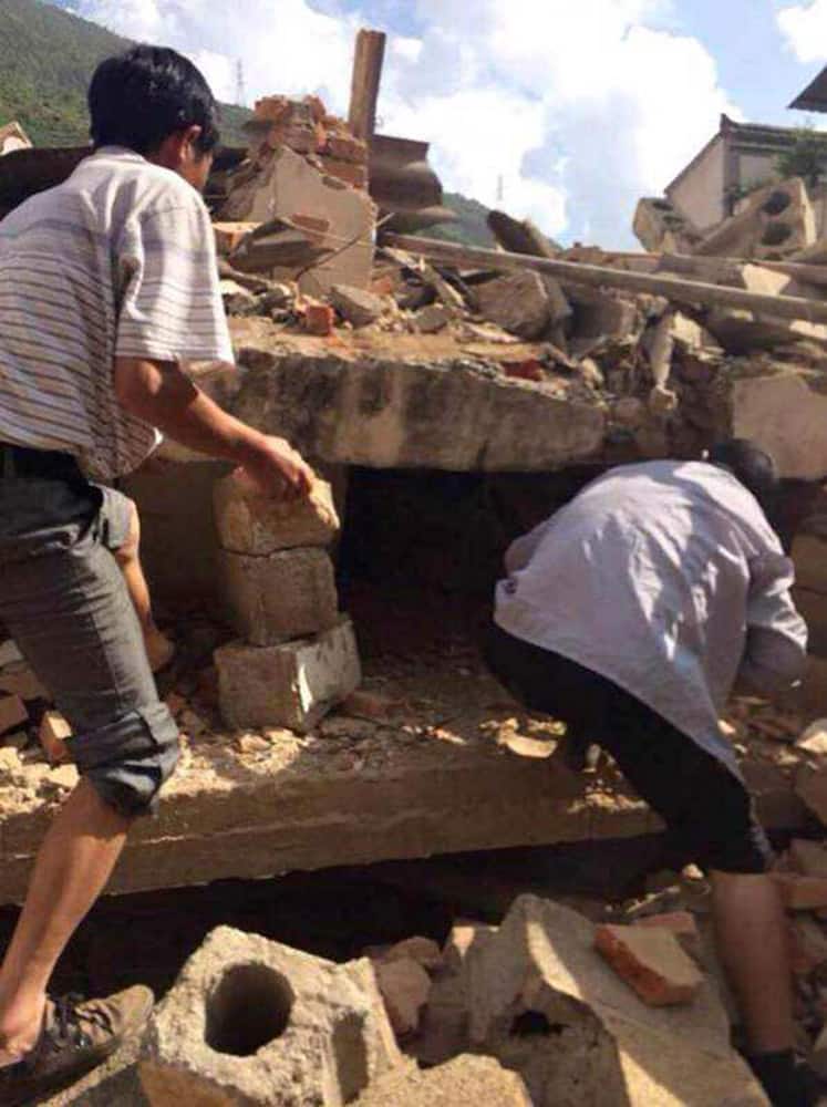 In this photo taken by cellphone and released by China`s Xinhua News Agency, men at rubbles of buildings look for survivors after an earthquake in Ludian County of Zhaotong City in southwest China`s Yunnan Province.