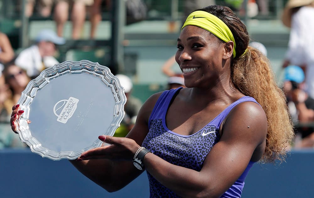 Serena Williams holds the winner`s trophy after beating Angelique Kerber, of Germany, during the championship match of the Bank of the West Classic tennis tournament, in Stanford, Calif.