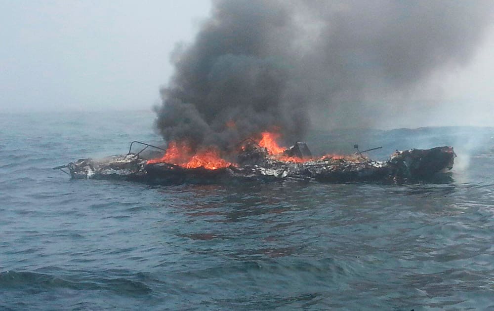 In this photo provided by the US Coast Guard, a 25-foot pleasure craft is engulfed in flames 3 miles north of Neah Bay, Wash.