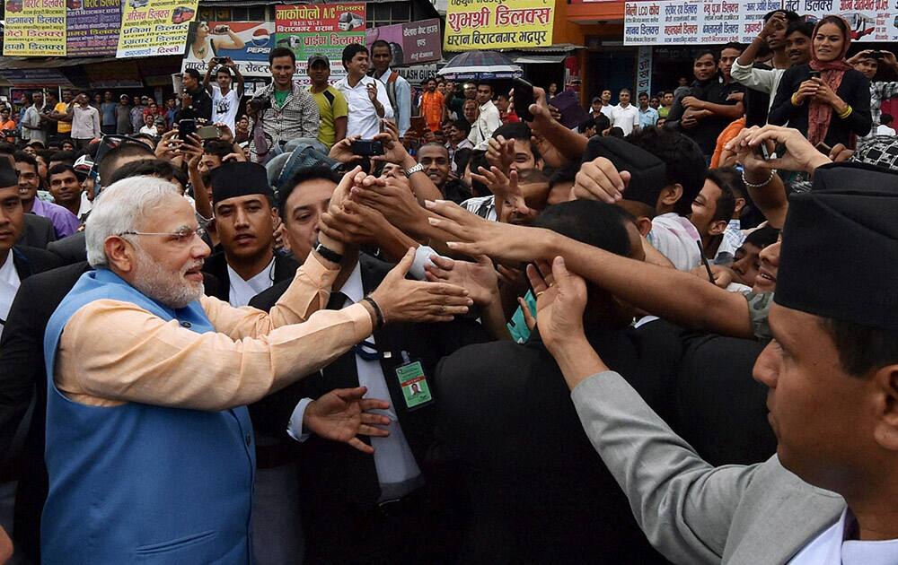 Prime Minister Narendra Modi greets people on the streets on his way back to the hotel after addressing the Nepalese Parliament in Kathmandu, Nepal.