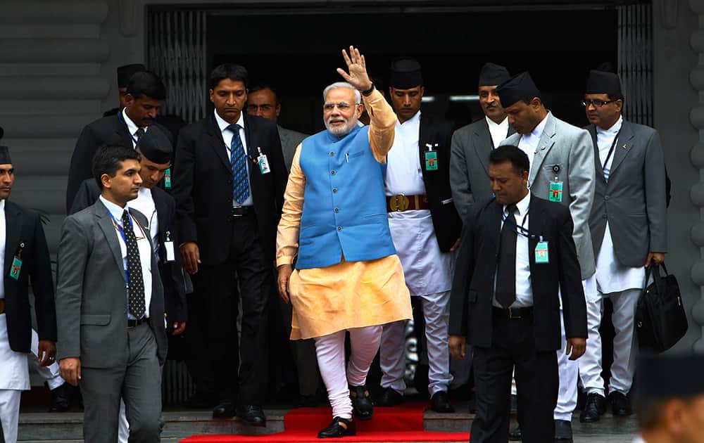 INDIAN PRIME MINISTER NARENDRA MODI, CENTER, WAVES TO THE MEDIA AS HE COMES OUT AFTER A MEETING WITH HIS NEPALESE COUNTERPART SUSHIL KOIRALA, AT THE PRIME MINISTER`S OFFICE IN KATMANDU, NEPAL.