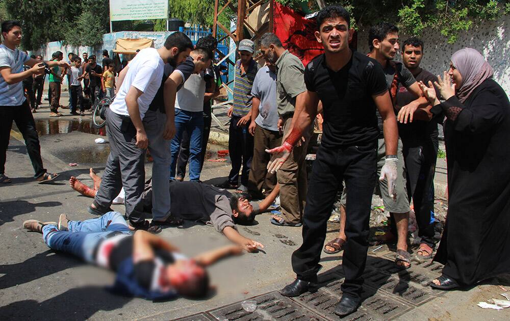 Men inspect dead and wounded Palestinians outside a UN run school in Rafah, in the southern Gaza Strip. UNRWA`s Director of Operations in the Gaza Strip said preliminary findings indicated the blast was a result of an Israeli airstrike near the school that been providing shelter for some 3,000 people.